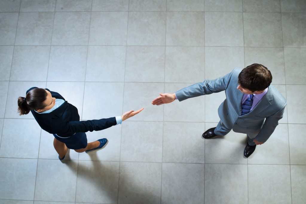 image of a businessmen stretching out their hands towards each other, the future handshake
